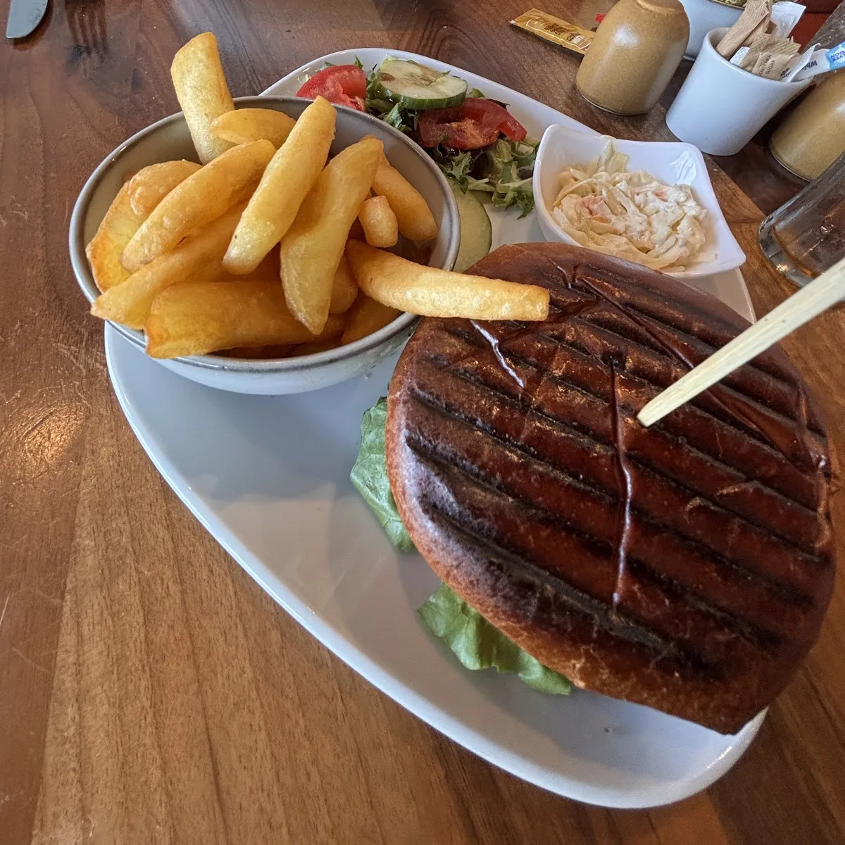 A brioche bun burger with chunky chips, salad and coleslaw at Isla Bay